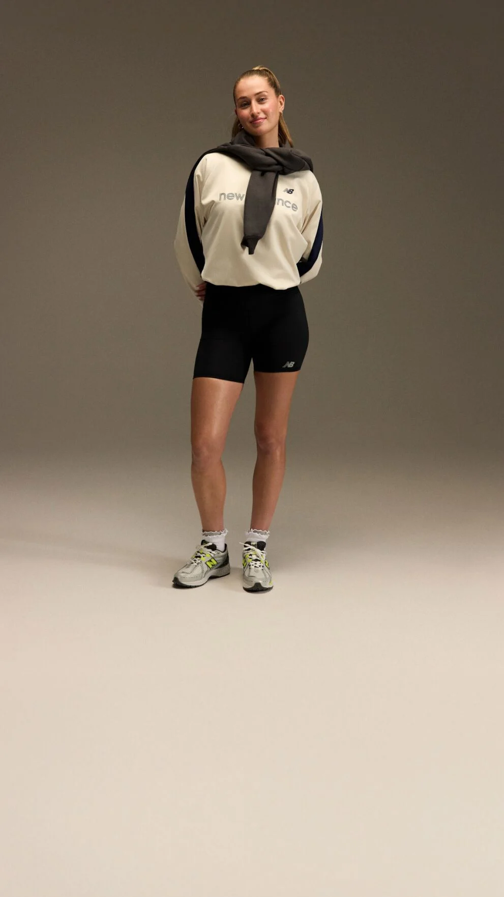 Jordyn Huitema standing with an athletic outfit in front of a brown and tan background